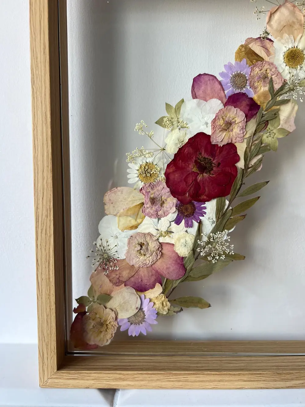 Oak frame with a pressed cascade of burgundy roses, hydrangea and gypsophila